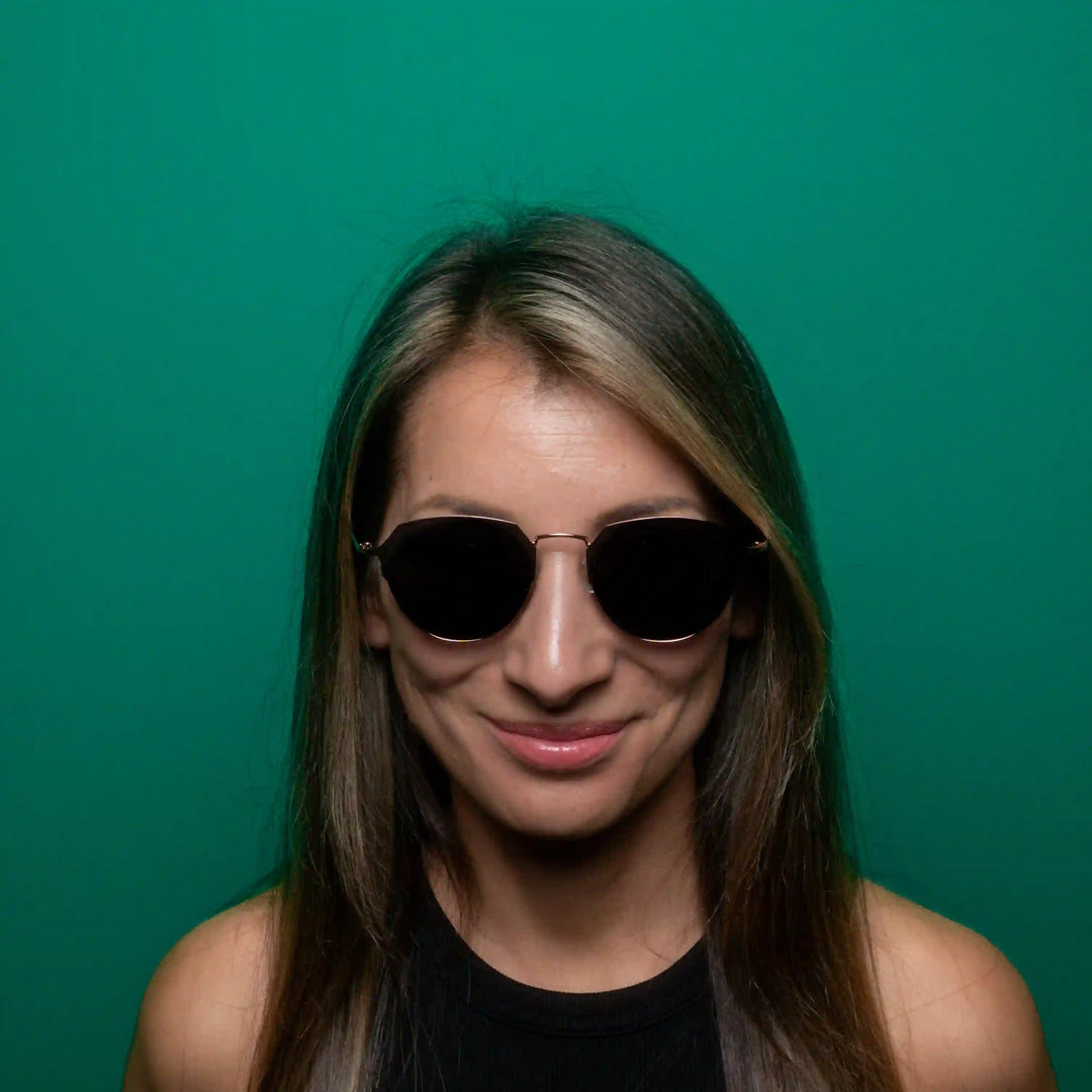 Woman wearing sunglasses with a green background